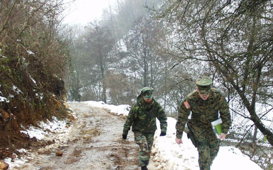 Marine Maj. John Church, right, walks with his interpreter up an icy hill near the Serbian town of Strpce.
