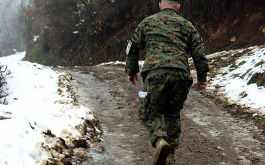 Marine Maj. John Church walks up an icy hill near the Serbian town of Strpce.
