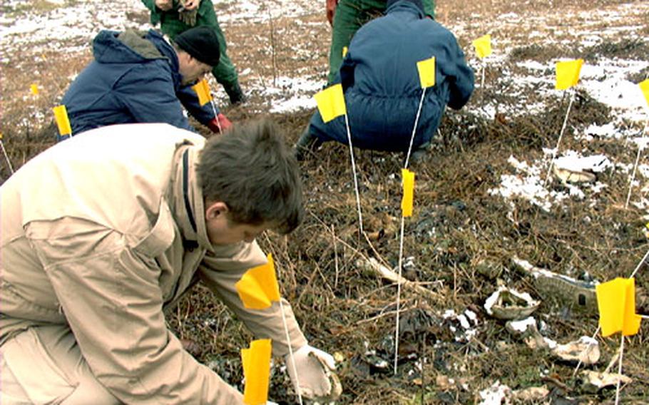 Dr. Rifat Kesetovic, the chief of forensics of the Project for Identification of Podrinje, digs around the remains of one of five bodies discovered earlier this month, five years after they were shot on their escape route from Srebrenica to Tuzla.