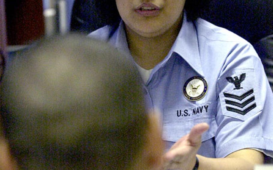 Navy Counselor 1st Class Neilyn Dionisio gives career advice to a young sailor at Yokosuka Naval Base.