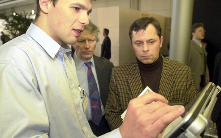 Marc Oldenburg, a Microsoft vendor, demonstrates new software on a tablet computer to visitors at the CeBit technology trade show in Hannover, Germany, in March.