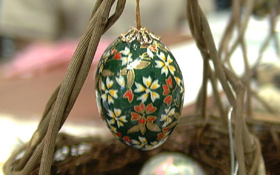 A colorfully decorated chicken egg — the final product of a washi craft class — hangs from a handmade basket.
