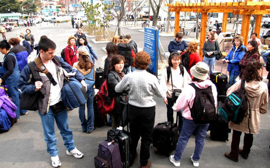 A group on U.S. Forces Korea residents playing the role of evacuees in an exercise March 28 gather outside the train station at Pohang, South Korea.