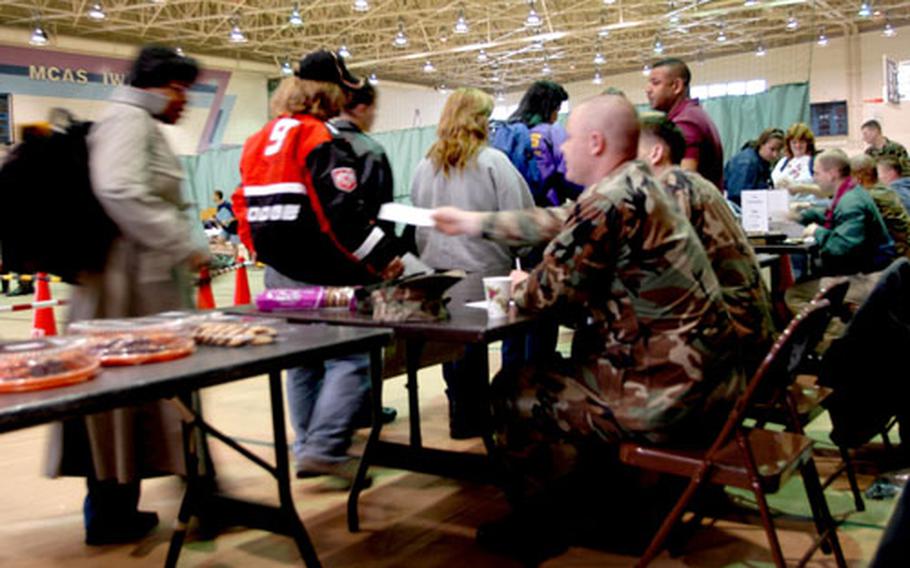 U.S. Forces Korea residents playing the role of evacuees in a exercise work their way through a reception area at Iwakuni Marine Corps Air Station, Japan, on March 29.