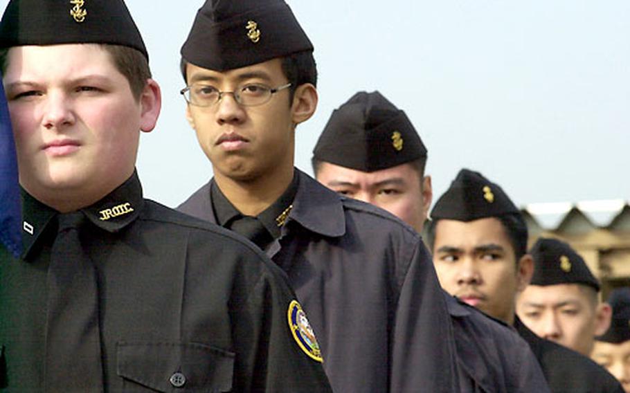 JROTC Cadet Christopher Woody is the guidon carrier during marching drills in the Kinnick High School courtyard.