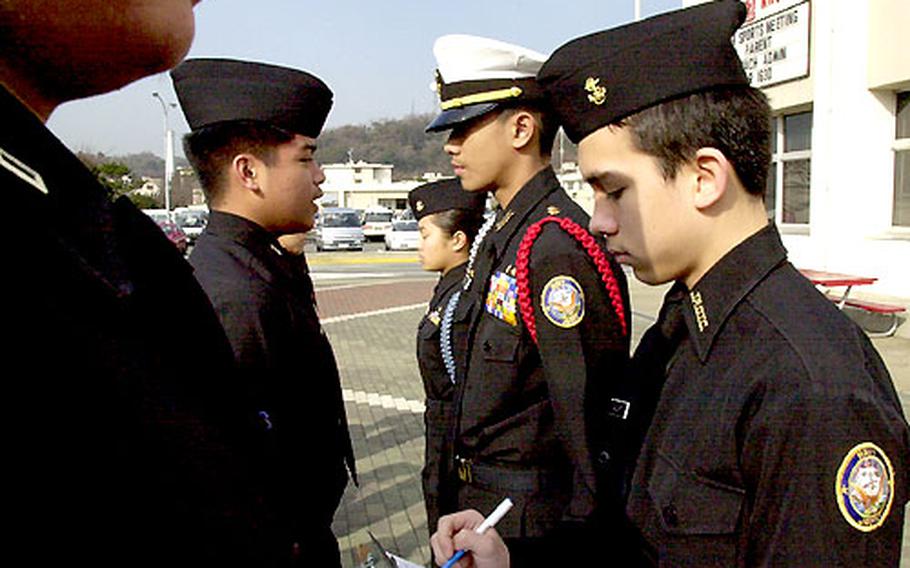 JROTC Cadet Eddie Calvert is the yeoman writing down discrepancies while Ervin Mercado performs a personnel inspection.