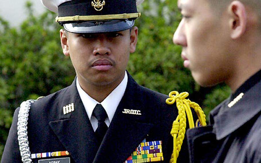 Junior ROTC Cadet Edgardo Agbay looks over his unit during a marching drill at Kinnick High School.