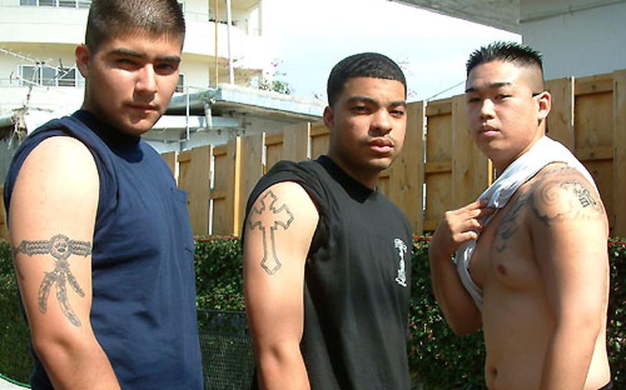 Three airmen from Kadena Air Base — Joseph Hunt, Tristin Bailey and Calvin Tang — show off their tattoos.