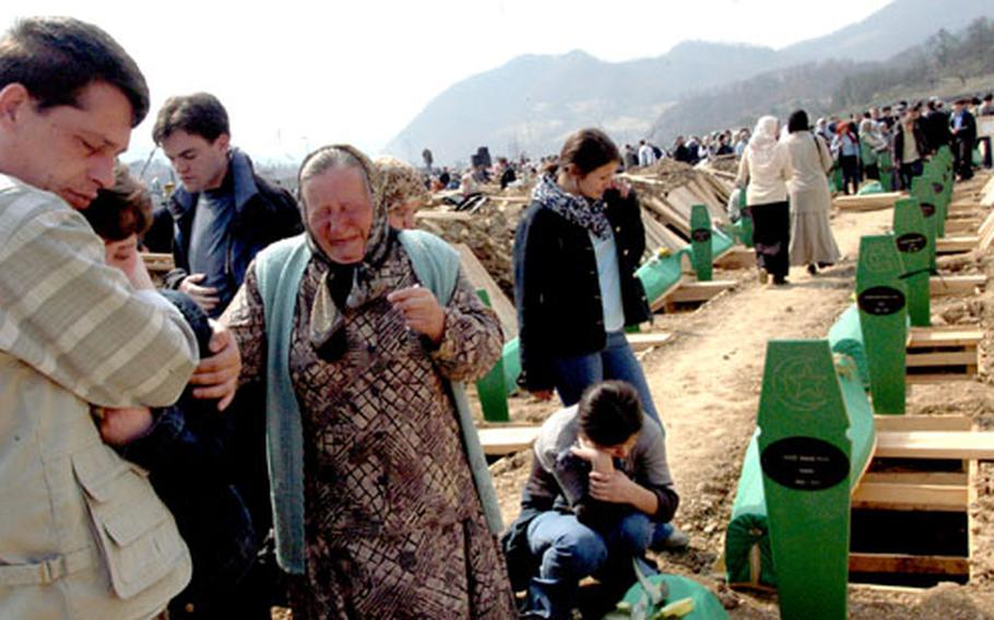 Family members comfort one another as the first victims of the Srebrenica massacre are buried.