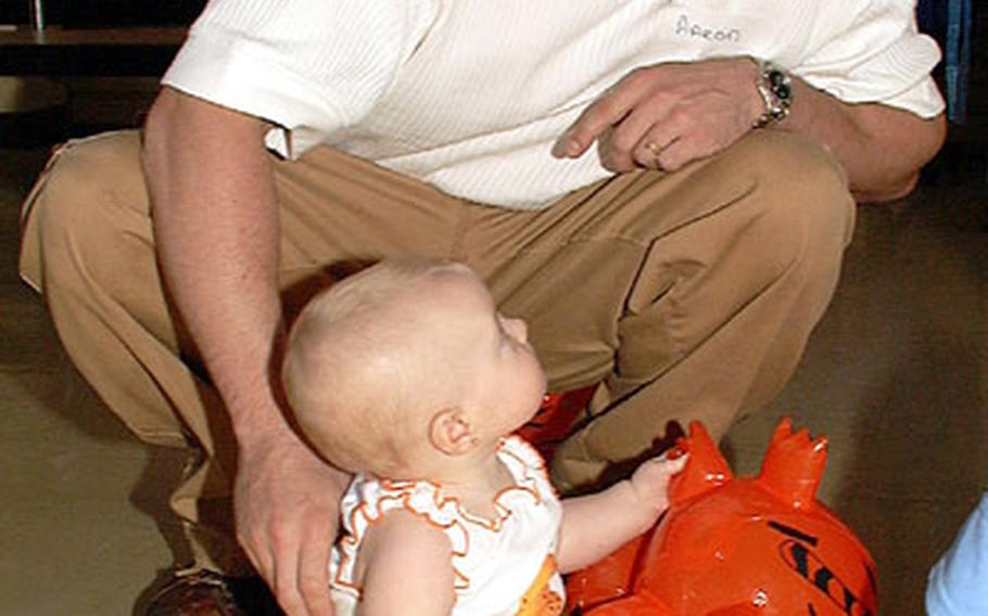 Air Force Staff Sgt. Aaron Burton plays with his daughter Kylee, now 10 months old. Kylee spent one week at the U.S. Naval Hospital’s Neonatal Intensive Care Unit on Okinawa and attended this year’s reunion for all NICU babies.