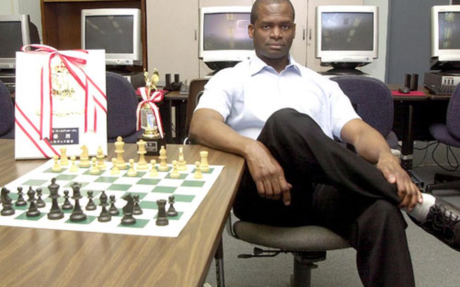Dexter Thompson teaches computer skills to students at Sasebo Naval Base in Japan by day, but in his spare time exercises his considerable chess skills. In early May, he won the 2003 All-Japan Golden Open Chess Championship in Tokyo (trophy on the far left), and in April won the 2003 Kyushu Chess Championship held in Fukuoka.