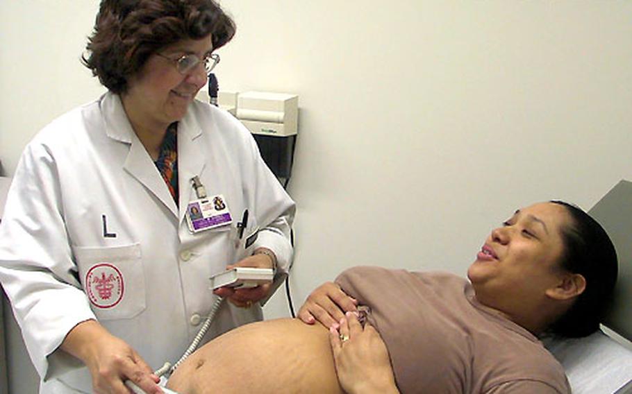 Army Lt. Col. Maria Barnes, a certified nurse midwife, examines a mother-to-be at the U.S. Army’s medical facility in Heidelberg, Germany.