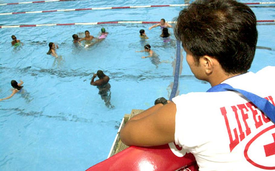 People who work outdoors, including lifeguard Kanazuka Takeshi at the Yokosuka Naval Base pool, need to be vigilant in applying SPF 30 sunscreen to avoid skin damage that could lead to skin cancer. The children might have entered the pool wearing sunscreen, but they’ll need to reapply after toweling off.