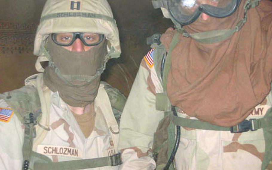 Capt. Schlozman, left, commander of Charlie Battery, 6th Battalion, 52nd Air Defense Artillery Regiment, and Lt. Michael Rodick, Charlie Battery&#39;s executive officer, pose during a dust storm at Camp Virginia, Kuwait.