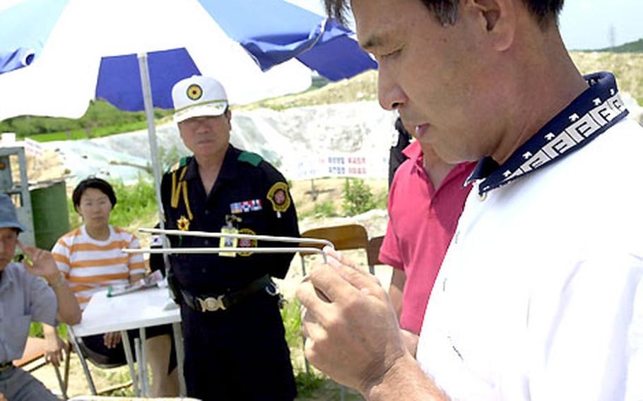 Choe Min-young illustrates how he used dowsing rods to allegedly find a North Korean infiltration tunnel near Hwaseong City. Choe, who worked for Samsung Construction in Iraq in the early 1980s, used dowsing there to find underground lines.
