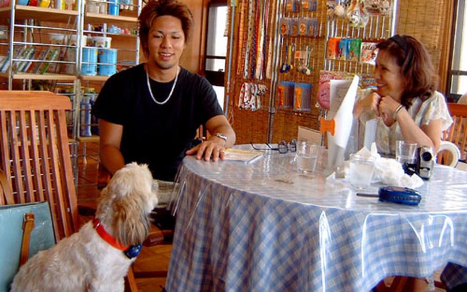 Fujiko, a Shih-Tzu, from Urasoe, enjoys a meal with her human family members. Her owner, Sugako Hasegawa, right, put a Bowlingual bark translator on her, but she preferred other types of communication with her human brother Ippei.