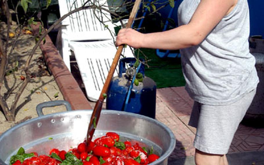 Carmela Pollio, 36, from Naples, mixes the San Marzano tomatoes with fresh basil leaves, salt and some water beneath.