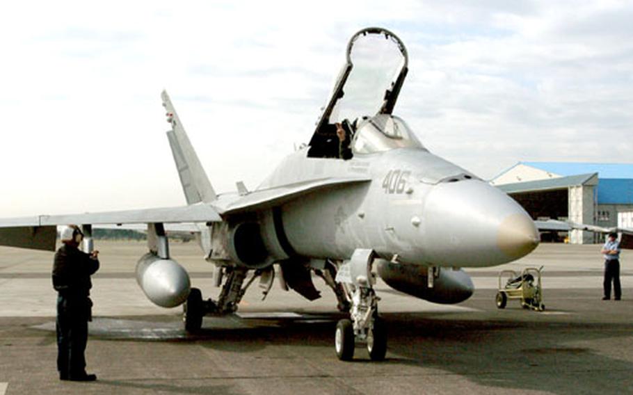 A plane captain runs through the startup sequence using a series of signals to the pilot.