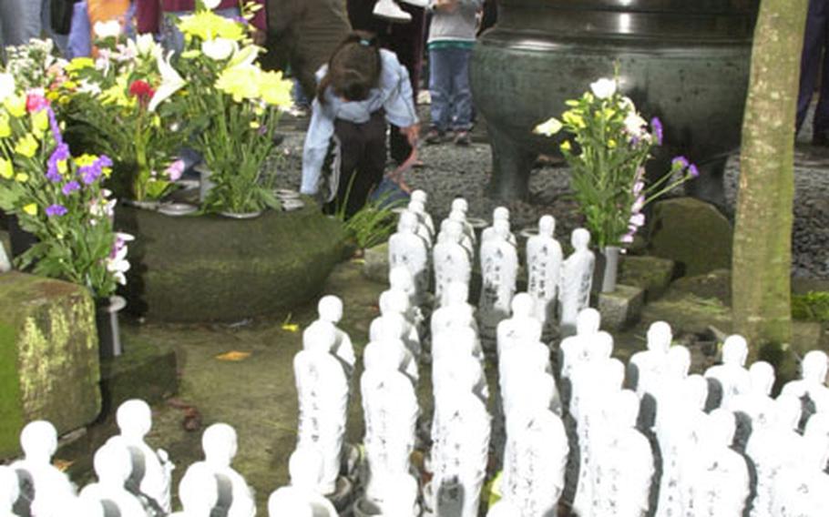 The tour group from Camp Zama looks at small statues that are part of a Buddhist practice for deceased children.