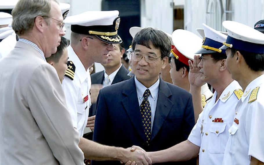 Vietnamese officials greet Cmdr. Richard Rogers, the commanding officer of the Vandegrift, and Raymond Burghardt, the U.S. ambassador to Vietnam. The visit symbolizes the normalization of relations between the two nations.