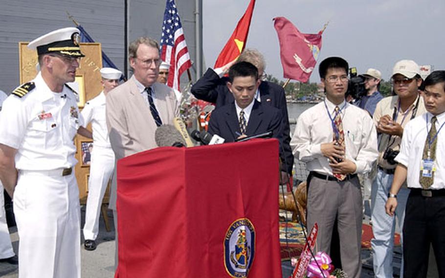 Cmdr. Richard Rogers, left, joins Raymond Burghardt, the U.S. ambassador to Vietnam, center, for a press conference on the Vandegrift.