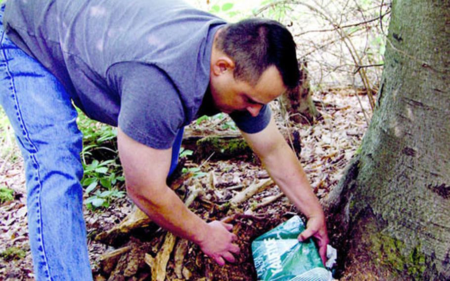 Air Force Tech Sgt. Marty Warg returns a cache to its hiding spot. Geocaching is growing in popularity, with caches hidden in more than 200 countries.