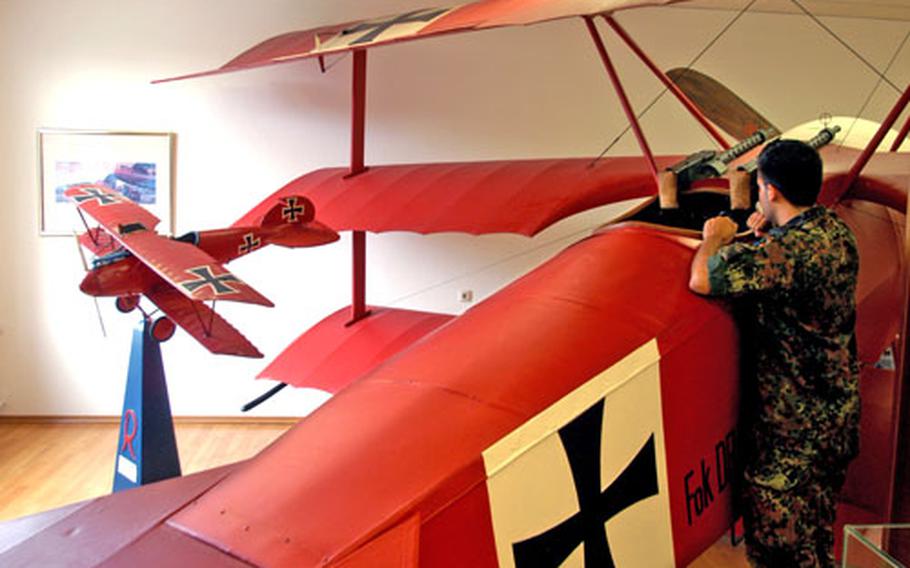 A German soldier at Wittmund studies the cockpit of a life-size replica of Manfred Freiherr von Richthofen&#39;s Fokker DR. I. This is the plane the Red Baron is always associated with, but most of his air victories were archived in an Albatros like the small model at left.