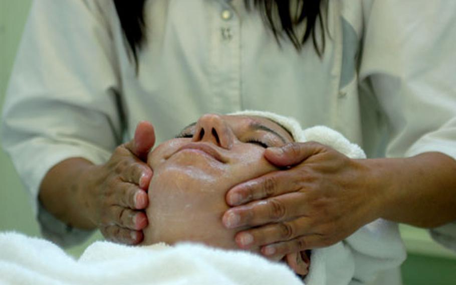 Maydelyn Reyes receives a facial from Joy Emerson, a cosmetologist and mass...