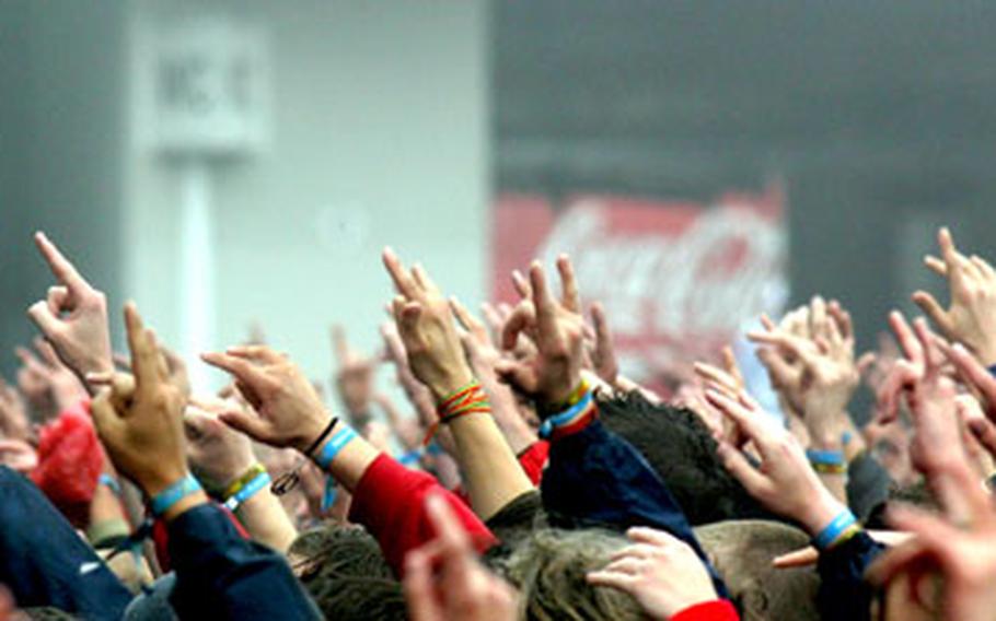 Fans, wearing the wristbands that serve as tickets to the three-day Rock-am-Ring fest, are packed in around the three stages.