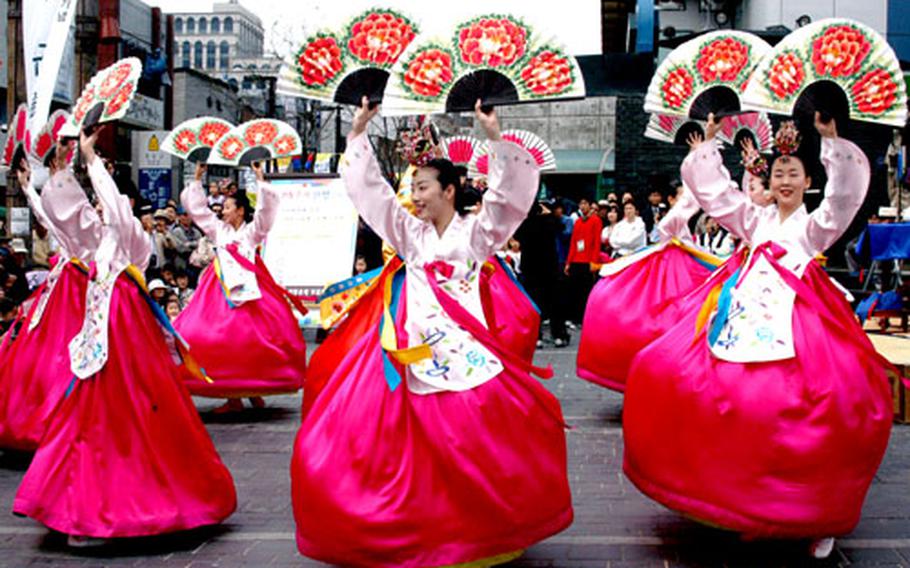 Dancers parade through the market after finishing a performance.