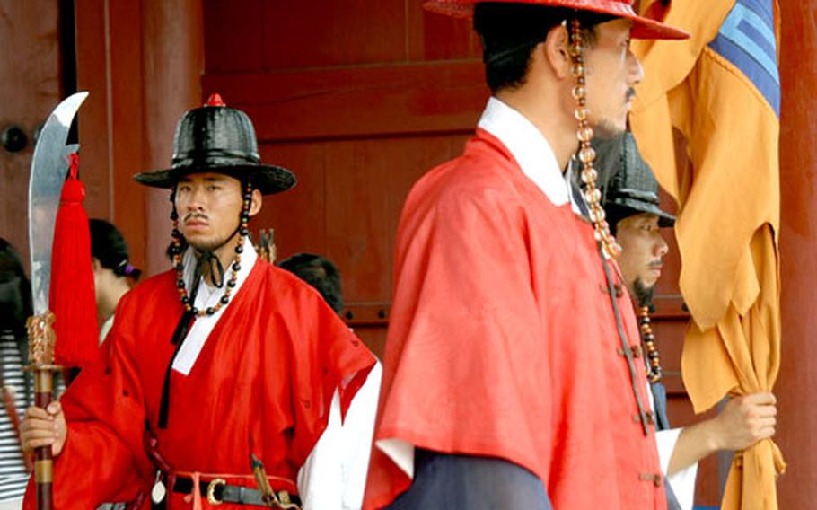A guard stands solemnly at the main gate of Gyeongbokgung Palace.