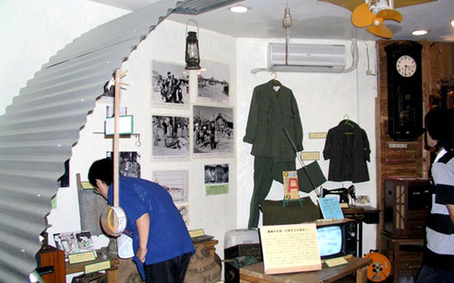 A visitor examines items displayed in a recreated room inside a Quonset hut at Histreet, a museum near Kadena Air Bases’s Gate 2. The museum recreates the life of people who lived in Okinawa City, then called Koza, after World War II.