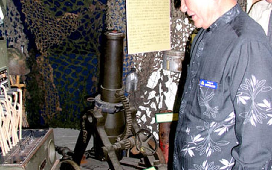 Mayor Masakazu Nakasone examines a telephone switchboard used by U.S. military during the Battle of Okinawa.