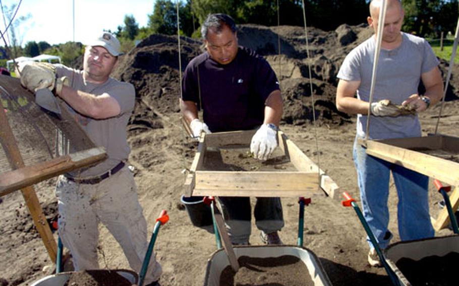 Members of the Joint POW/MIA Accounting Command recovery team — from left, Air Force Master Sgts. David Metherell and Rodney Acasio, and Army Sgt. Jimmy Phillips — screen dirt at the site.