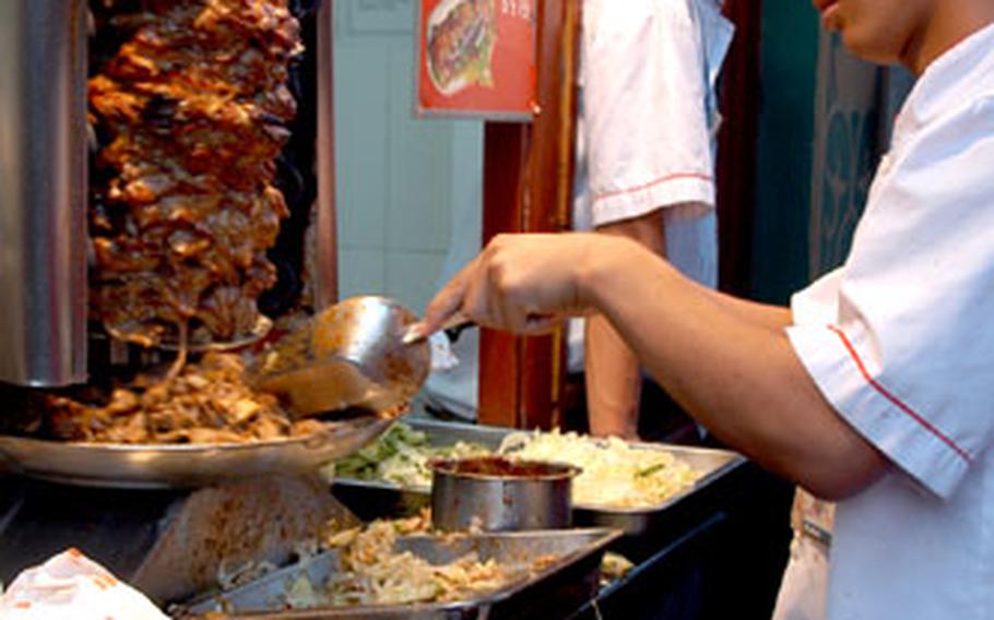 Turkey is sliced from a rotisserie then stuffed into a pocket bread at the outdoor food court at Wangfujing Daije shopping area.