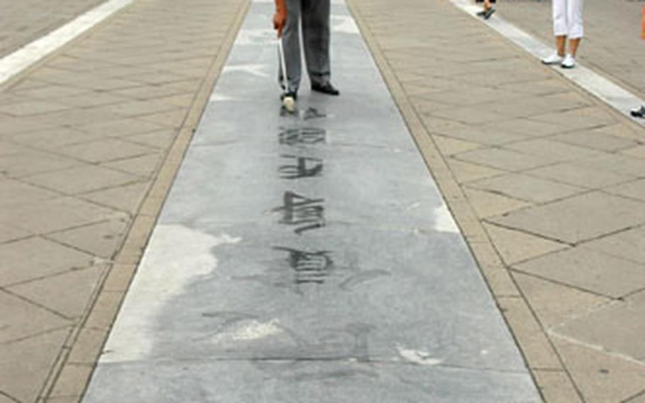 A man practices calligraphy in the morning at the Temple of Heaven Park in southeastern Beijing. Many people gather at the park in the early morning hours to practice dancing, play sports and sing.