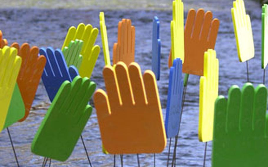 A collection of brightly colored hands, an art project, stands in the center of the Cheonggye Stream in downtown Seoul.