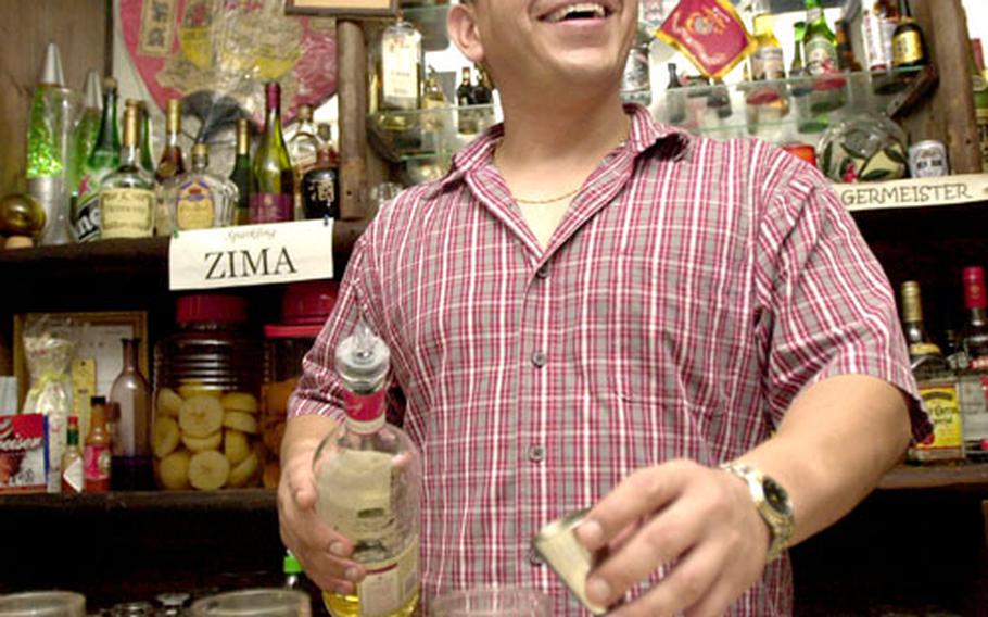 Tony laughs while pouring shots at his bar, Up To You, in Ginowan, Okinawa. The bar is on Highway 58 between camps Foster and Kinser. Tony prefers keeping his last name to himself.