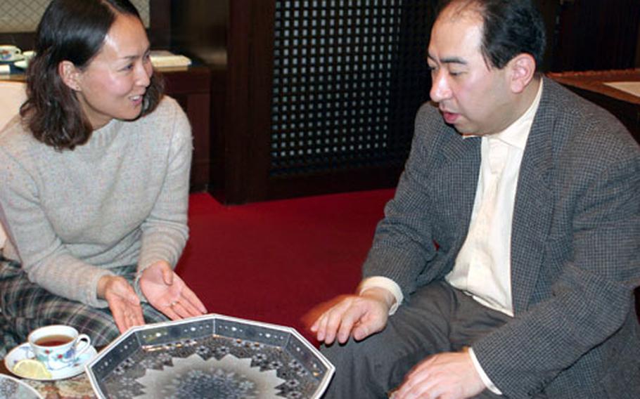 Satoe Mueller, wife of John Mueller, principal of Sasebo Naval Base’s Jack N. Darby Elementary School, and Imaemon XIV discuss his desire to observe tradition and his spiritual connection to his ancestors through the porcelain china he creates in Arita.