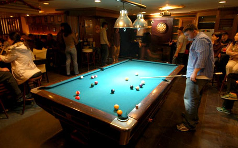 Customers play pool and darts at Jester’s, a local “everyone’s welcome” watering hole in Itaewon, South Korea.