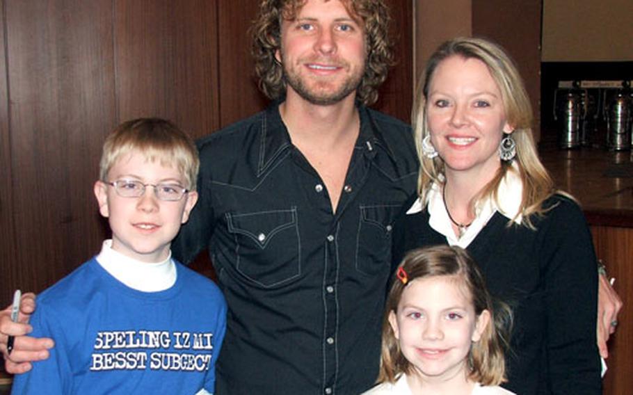 Dierks Bentley poses with long-time fan Carla Foster and her children, Megan, 8, and Zachary, 12 after a recent concert in Baumholder, Germany.