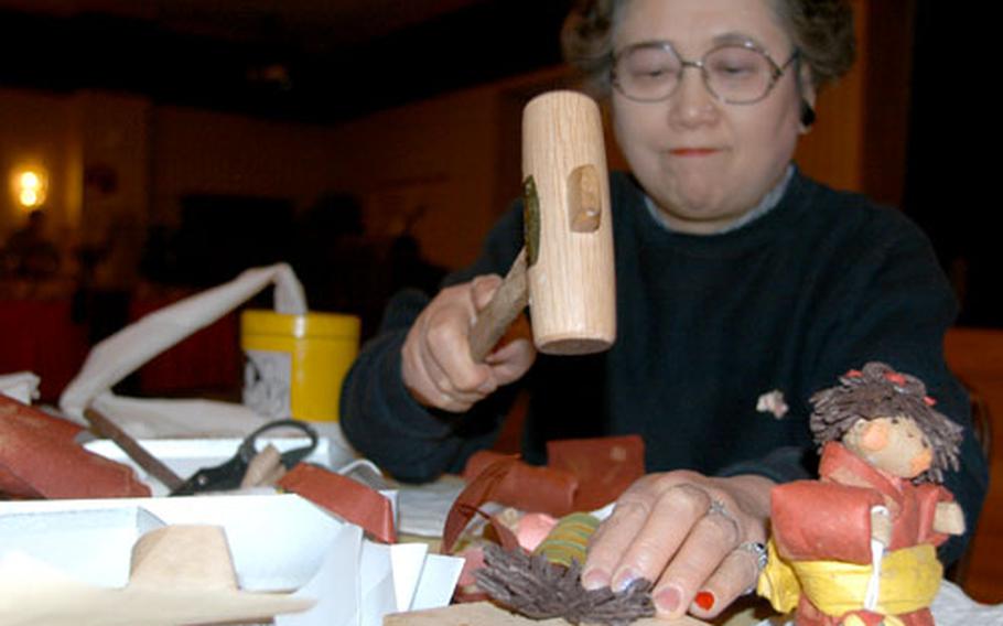 Ohyama uses a mallet to shape a doll. She estimates she’s made tens of thousands of dolls in her Kawauchi workshop.