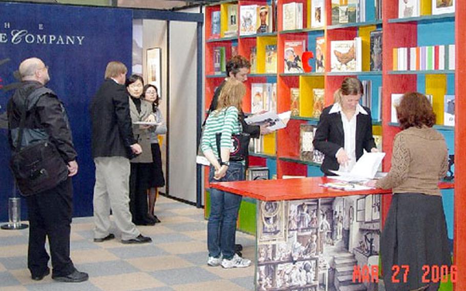 Attendees of a recent book fair in Bologna, Italy, browse books displayed by The Creative Company, a U.S. publisher of children’s fiction. Exhibitors from around the world pay to have booths at the fair.