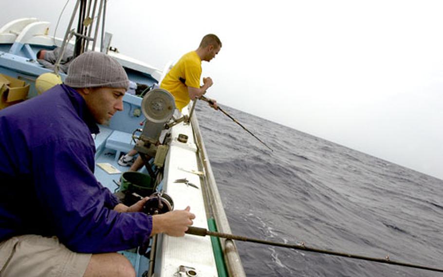 Marine Capt. Josh Rosen, foreground, and Navy Lt. James Quick drop lines in the water during a recent deep-sea fishing trip in the Pacific Ocean off the Eastern side of Okinawa.