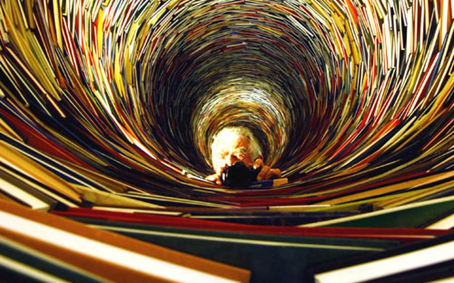 “Booktower,” a work of art by Slovakian artist Kren, is one of the surprising pieces at the museum. Hundreds of books and the photographer are refected by two mirrors, one at either end, creating an endless image.