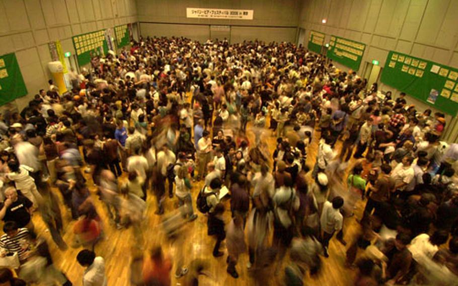 Hundreds of people with plastic shot glasses in hand cram into Garden Hall at Yebisu Garden Place in Tokyo for the Great Japan Beer Festival 2006.