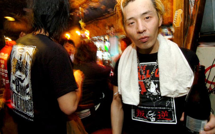A member of the Japanese rock band Save Our Soul takes a break between sets at The Chicken Shack on Bar Row in Fussa, Japan. The bar has live music five nights a week.