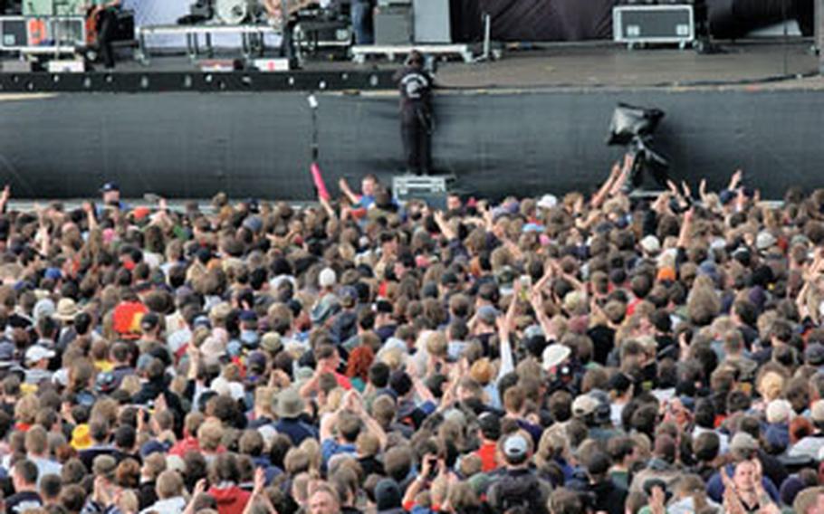 Tens of thousands of fans crowd in front of the main stage at Rock am Ring to watch the Scottish band Franz Ferdinand perform on the final day of the three-day festival.