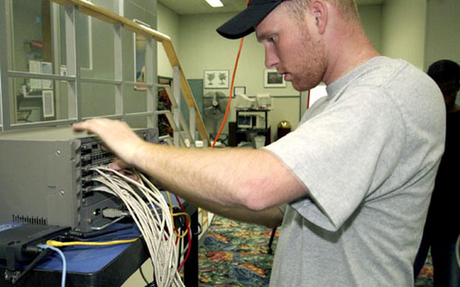 Staff Sgt. Michael Roszkowski of the 374th Communications Squadron helps set up for a CUGY LAN party on Yokota Air Base, Japan.