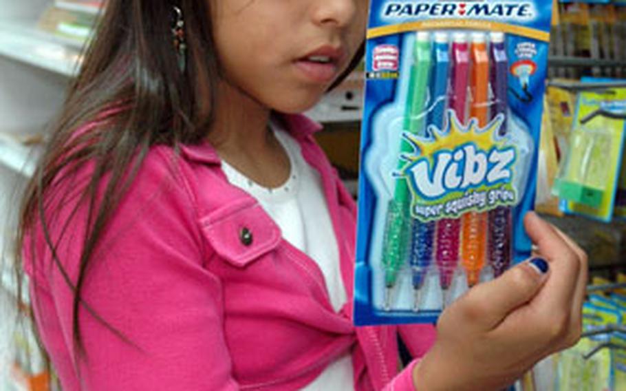 Cyenna Vieyra, 10, checks out some Paper Mate Vibz pencils ($2.50). She is wearing a two-piece top by Ponytails ($9.99), an AAFES brand.